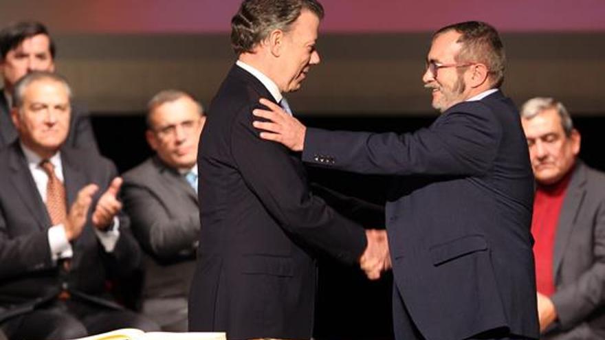  El presidente de Colombia, Juan Manuel Santos, y el jefe máximo de las FARC, 'Timochenko', tras la firma el nuevo acuerdo de paz. (EFE)