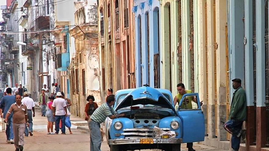 Cubanos intentan reparar un "almendrón" en La Habana. (SN)