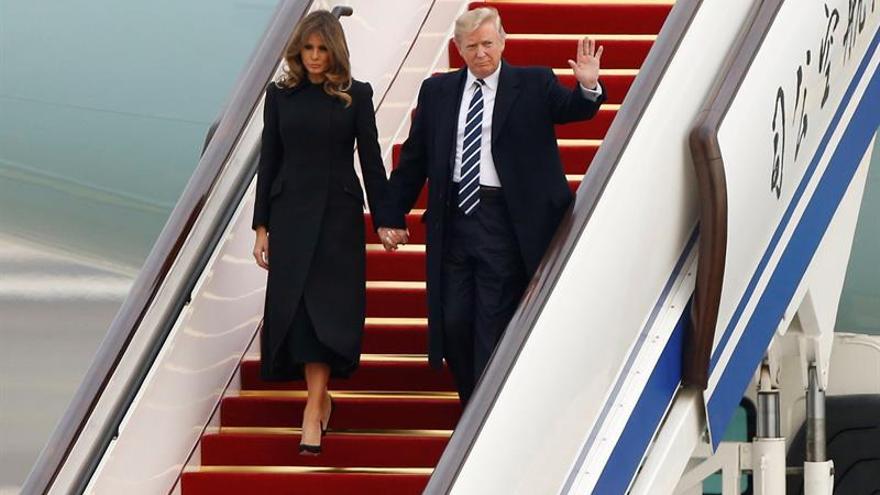 Melania y Donald Trump descienden del Air Force One para su primera visita de Estado a China, su rival como potencia mundial. (EFE/ Thomas Peter)