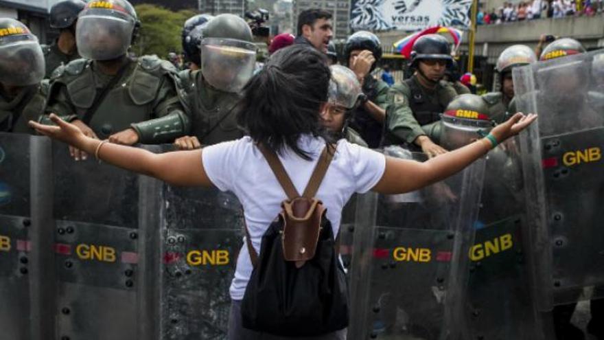 Una joven se enfrenta a la Policía durante una protesta en Venezuela. (EFE)