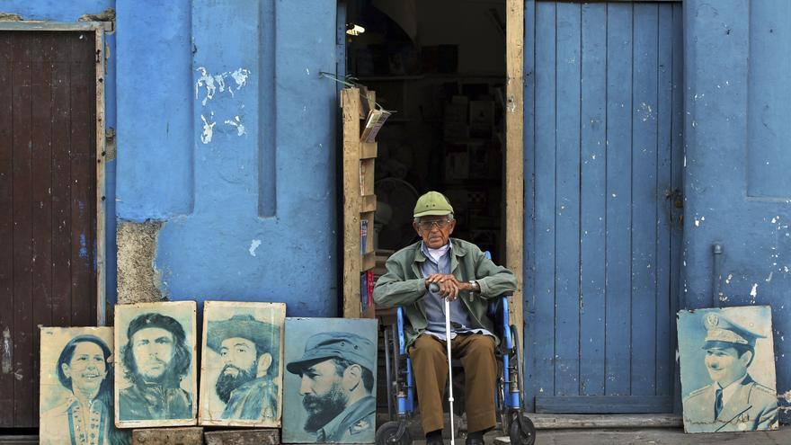 Un anciano con cuadros de dirigentes revolucionarios en La Habana. (EFE)