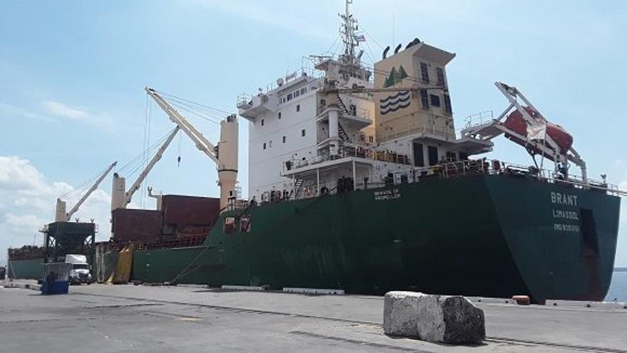 Barco en el puerto de Cienfuegos, donde se encuentra almacenada la gravilla que viajará a México. (ACN)