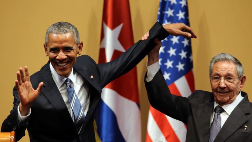 El gobernante cubano Raúl Castro trata de levantar el brazo del presidente de EEUU, Barack Obama, después de una conferencia de prensa en La Habana. (EFE)