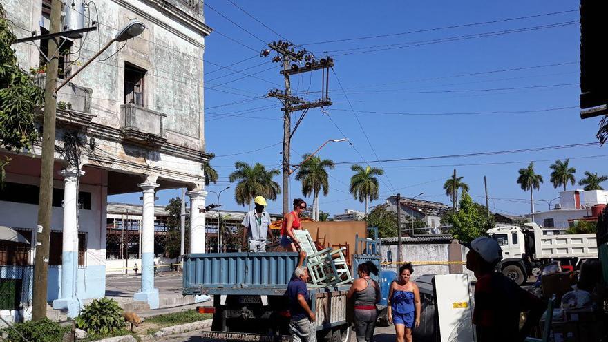 Por la calle Colón un grupo de vecinos aguardan un camión que ha mandado el Gobierno para trasladar sus pertenencias a otro lugar. (14ymedio)