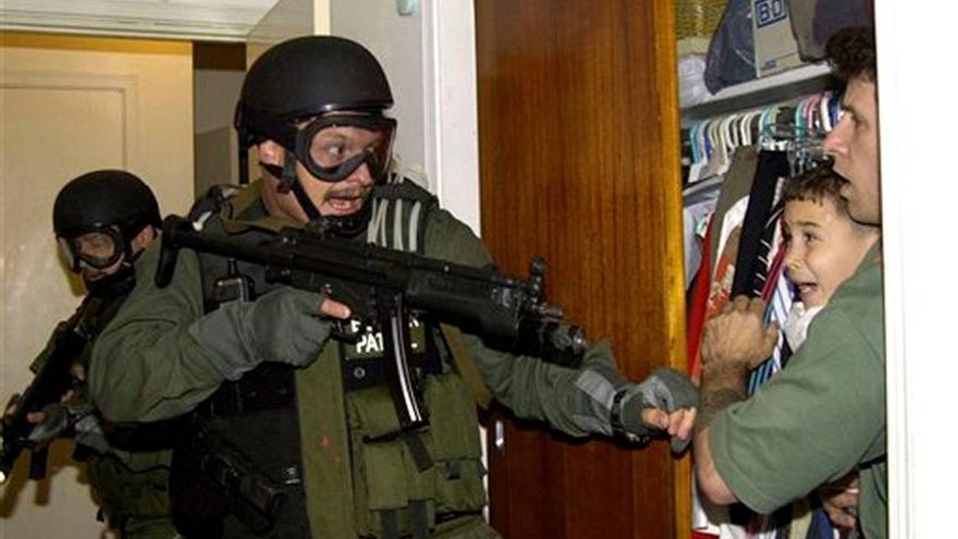En esta icónica foto, Donato Dalrymple protege a Elián en un closet, de los agentes federales que registraban la casa de su familia en la Pequeña Habana, el 22 de abril del 2000. (Archivo)