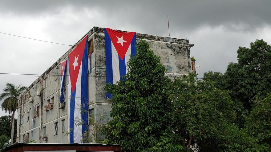 Inmensas banderas cubanas fueron desplegadas para tratar de cubrir las ventanas de la casa de Yunior García Aguilera. (Facebook)