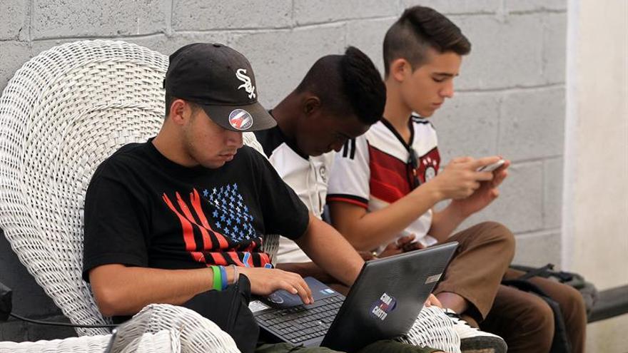 Jóvenes cubanos intentan acceder a una red wifi del Museo Orgánico de Romerillo. (EFE)