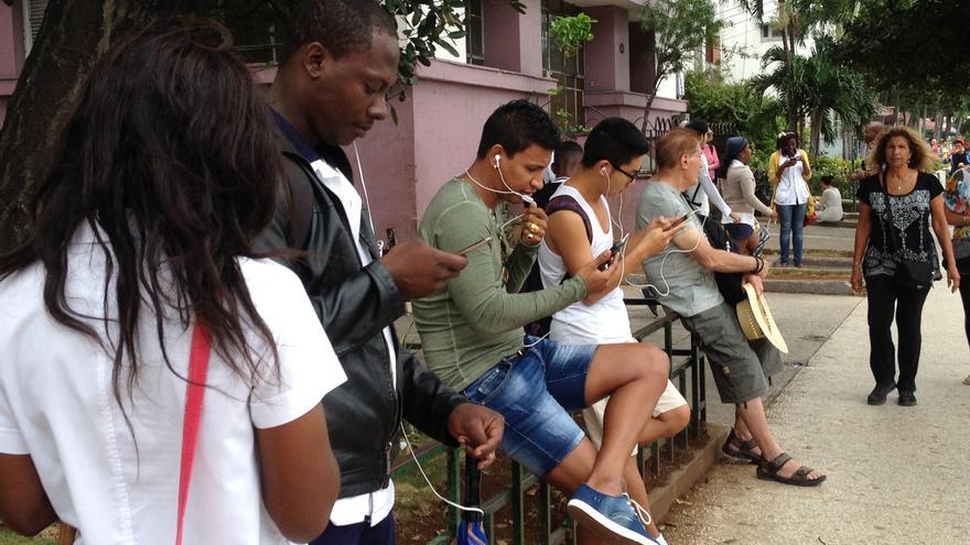 Jóvenes utilizan sus teléfonos celulares para conectarse a la red wifi en La Habana. (14ymedio) 