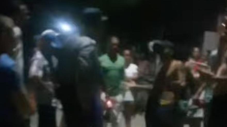 Momento de un video durante las segundas protestas en Nuevitas, la madrugada del sábado, en el que se observa a los manifestantes encarándose con un agente. (Captura) 