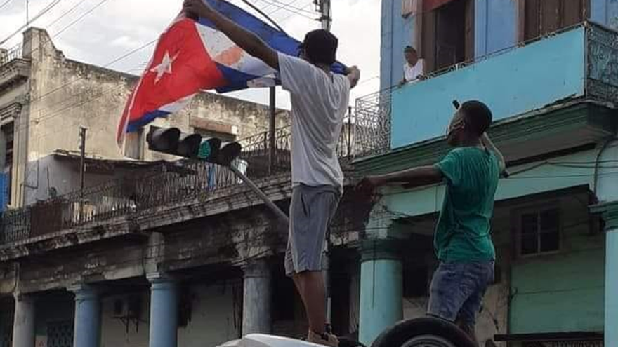 Momento en que varios jóvenes vuelcan una patrulla en la esquina de Toyo, La Habana, el pasado 11 de julio. (Facebook)