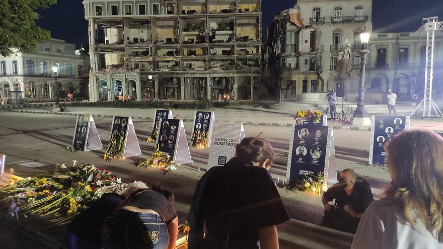 Personas ponen velas y observan los retratos de los fallecidos en la explosión del hotel Saratoga, en La Habana. (14ymedio)