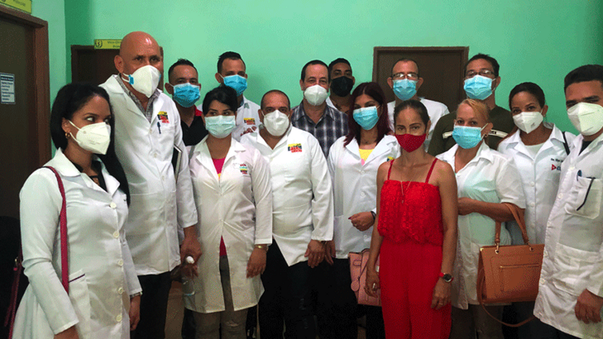 El ministro de Salud, José Ángel Portal Miranda, en el centro, con una veintena de médicos cubanos recién llegados de Venezuela. (PCC)