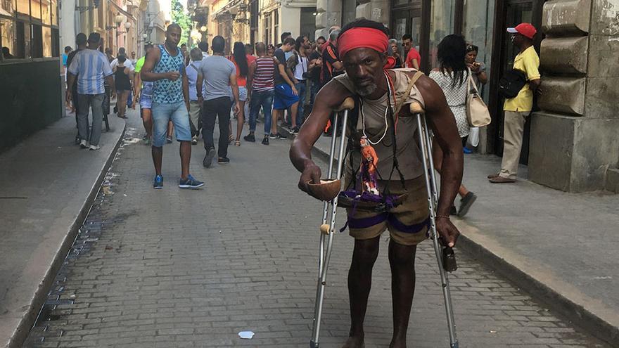 Un hombre muestra una imagen de San Lázaro en la céntrica calle Obispo de La Habana Vieja. (14ymedio)