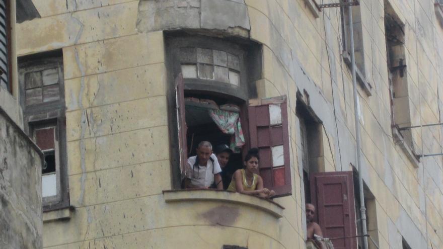 Vecinos atrapados en el edificio en derrumbe observan a través de las ventanas el despliegue policial. (14ymedio)