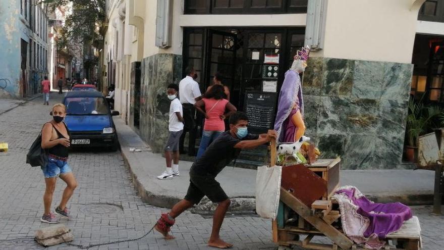 Un joven arrastra una efigie de San Lázaro por las calles de La Habana Vieja para pagar una "promesa". (14ymedio)