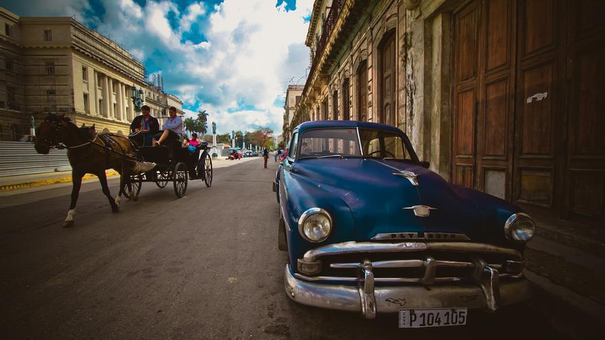 En las cercanías del capitolio de La Habana unos turistas pasean en un coche de caballos. (flickr)