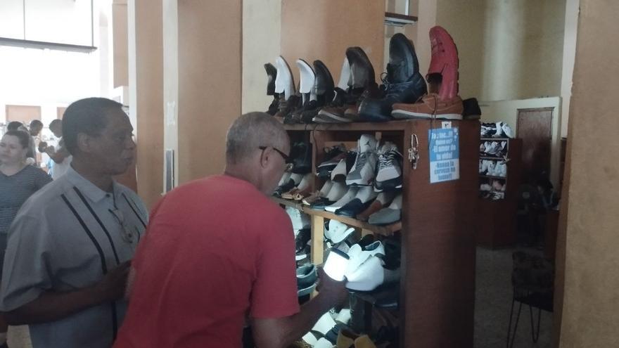 Dos clientes intentan ver unos zapatos en una tienda en Neptuno y Galiano. (14ymedio)