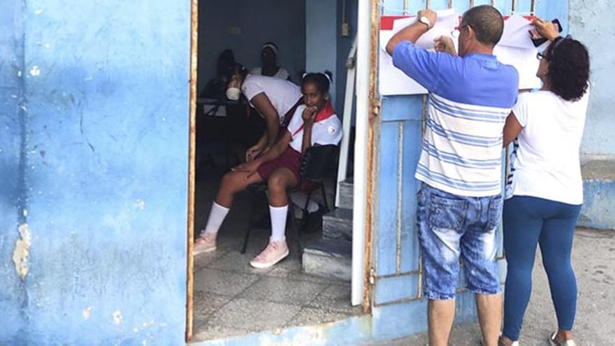 Una pareja de cubanos se busca en el patrón antes de ingresar al colegio de votación. (14ymedio)