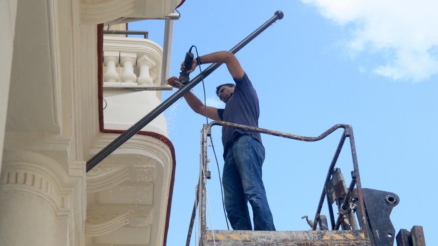 Un empleado dando “los últimos ajustes” en la fachada del Hotel Manzana Kempinski, en La Habana. (14ymedio)