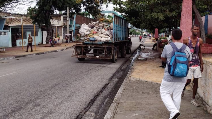 Sin camiones especializados y cargando los residuos uno a uno, así se recoge la basura en Santiago de Cuba. (14ymedio)