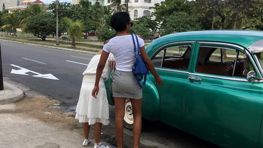 Dos mujeres abordan un taxi colectivo (almendrón) en La Habana. (14ymedio)