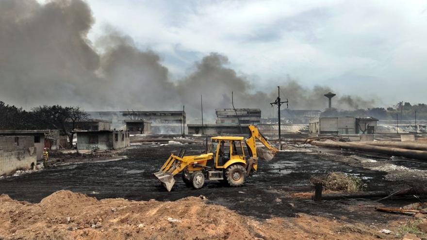 Una volqueta trabaja recogiendo los restos de los incendios en la zona industrial del puerto de Matanzas este 10 de agosto de 2022. (EFE/Ernesto Mastrascusa)