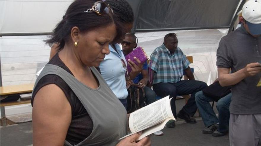 Una mujer revisa un volumen durante la Feria del Libro de La Habana. (14ymedio)
