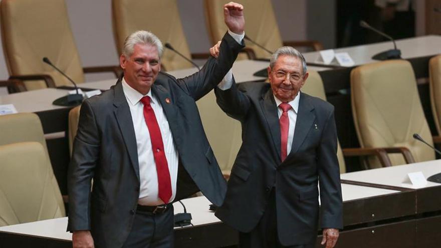 El primer secretario del Partido Comunista de Cuba y expresidente Raúl Castro levanta el brazo de Miguel Díaz-Canel tras su nombramiento. (EFE/Alexandre Meneghini)