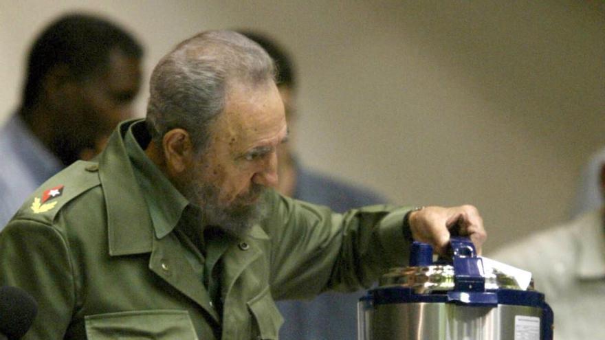 El expresidente cubano, Fidel Castro, sostiene una olla reina de fabricación china. (EFE)