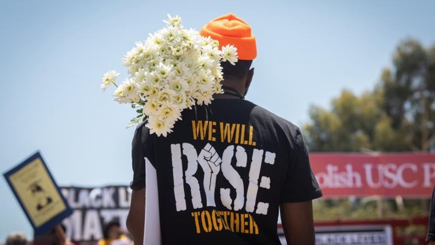 Un manifestante sostiene un ramo de flores en una manifestación organizada bajo el lema Black Lives Matter. (EFE/EPA/Christian Monterrosa)