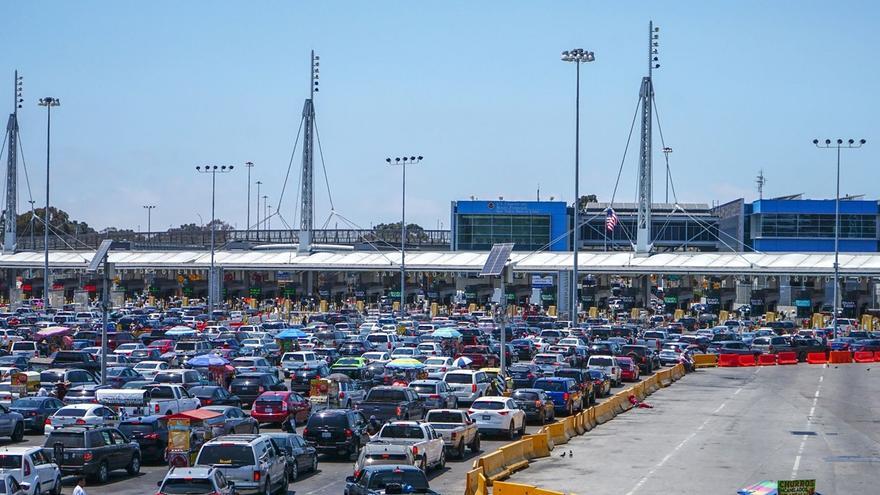 Cientos de coches esperan en el cruce fronterizo en la ciudad de Tijuana, el 14 de junio de 2021. (EFE/JOEBETH TERRIQUEZ)