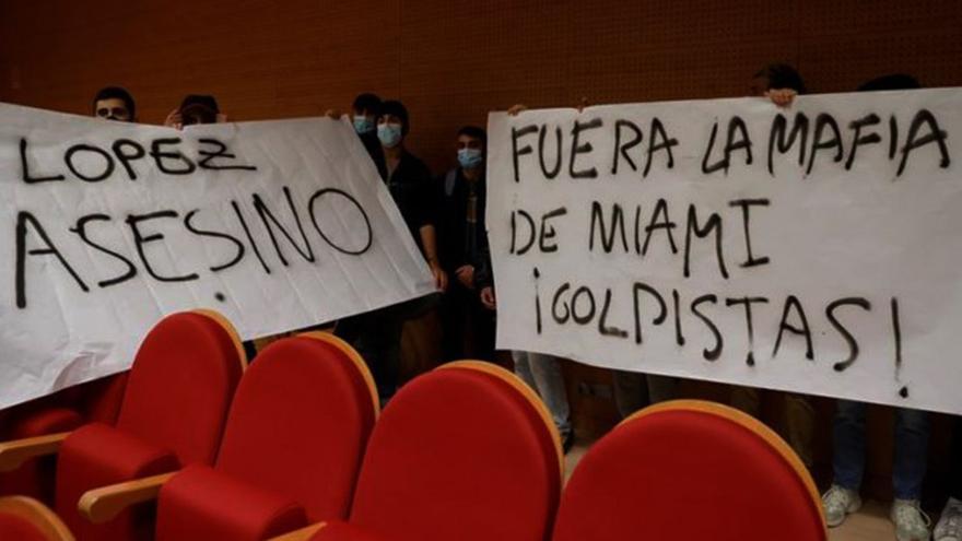 "¡Fuera la mafia de Miami, golpistas!" y "López asesino", decían los carteles desplegados por un grupo de poco más de doce jóvenes en la Facultad de Políticas de la UCM. (EFE)
