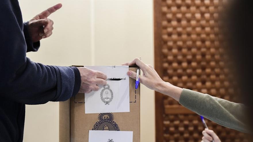 Un hombre deposita su voto en un centro electoral en Madrid, en la segunda vuelta de las elecciones presidenciales de Argentina. (EFE/ Víctor Lerena)