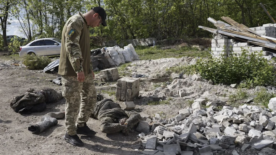 Un militar ucraniano observa el cadaver de un soldado ruso en Mala Rohan, cerca de Járkov. (EFE/EPA/Vasiliy Zhlobsky)