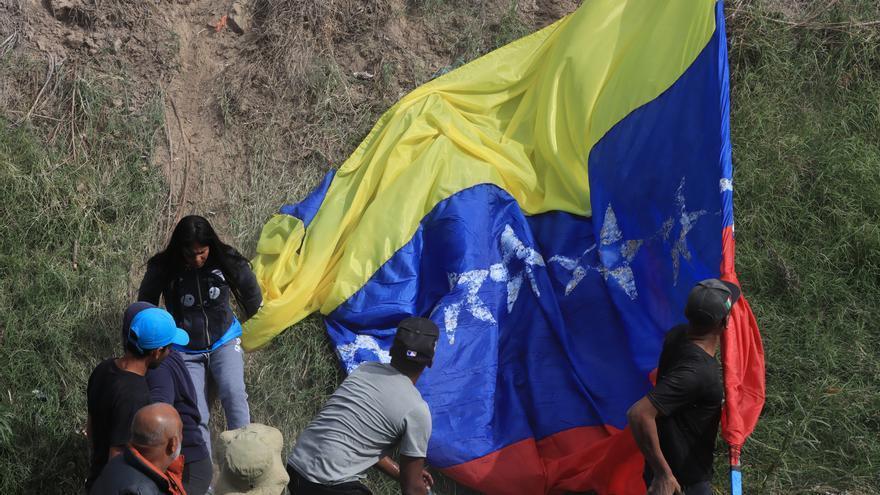 Los manifestantes, quienes ondearon banderas de México, Estados Unidos y Venezuela, caminaron por el borde del río Bravo, a unos metros del muro fronterizo. (EFE)