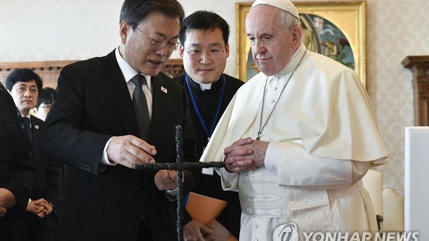 Moon entrega al papa una cruz hecha con el alambre de la zona militarizada entre las dos Coreas. (Vatican Media)
