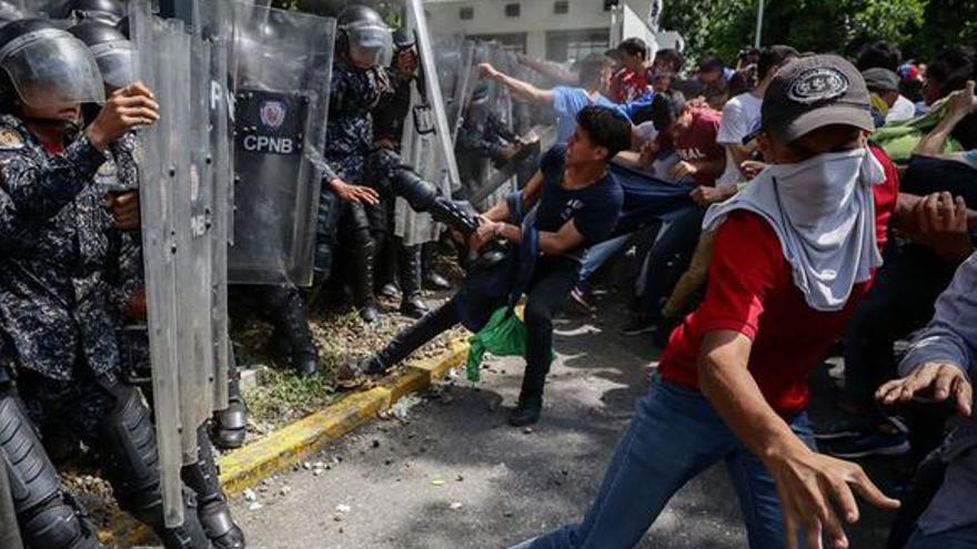 Jóvenes se enfrentan con miembros de la Policía Nacional Bolivariana en medio de una protesta de universitarios en Caracas, Venezuela, en una fotografía de archivo. (EFE/Rayner Peña)