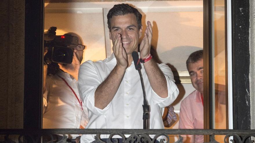 Pedro Sánchez saluda a los militantes socialistas desde el balcón de la sede del partido, en la calle Ferraz de Madrid. (EFE)