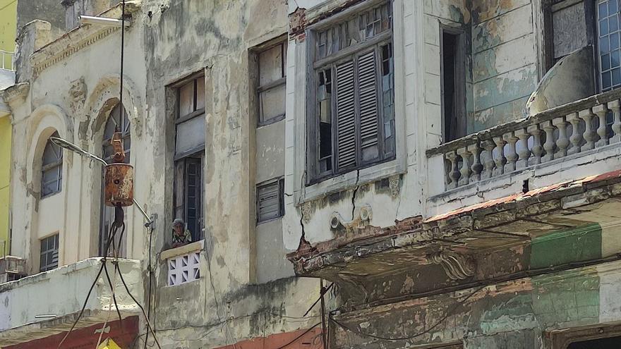 A neighbor leaned out to watch the demolition of the building next to hers.  (14ymedio)