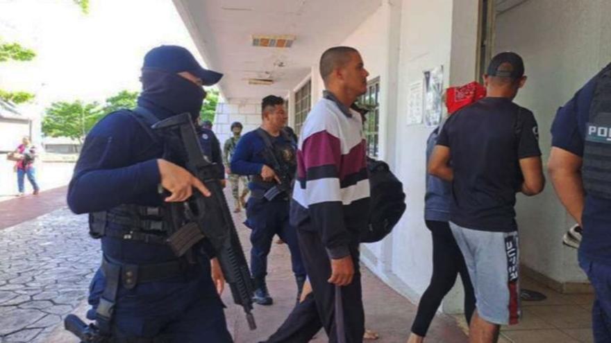 El grupo de 14 balseros cubanos fue escoltado, como si fueran delincuentes, por policías armados de Cozumel. (Facebook)