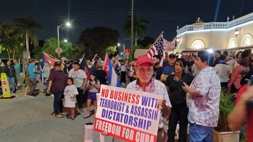 Uno de los carteles, en inglés, pedía "ningún negocio con la dictadura terrorista y asesina" y "libertad para Cuba". (14ymedio) 