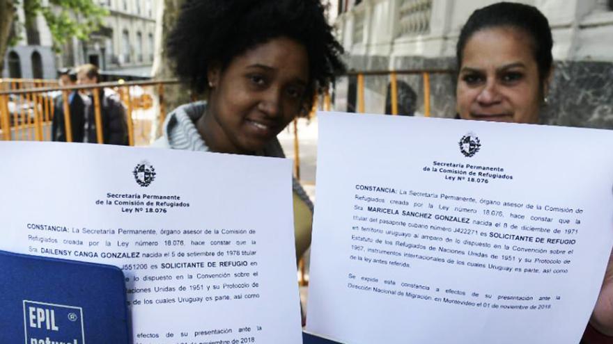 Dos cubanas muestran los documentos de solicitud de refugio tramitados en Uruguay. (El País)