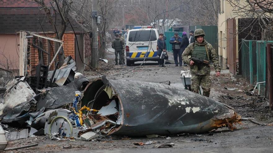 Un soldado pasa junto a los escombros de un avión militar que fue derribado en Kiev. (EFE/EPA/SERGEY DOLZHENKO)