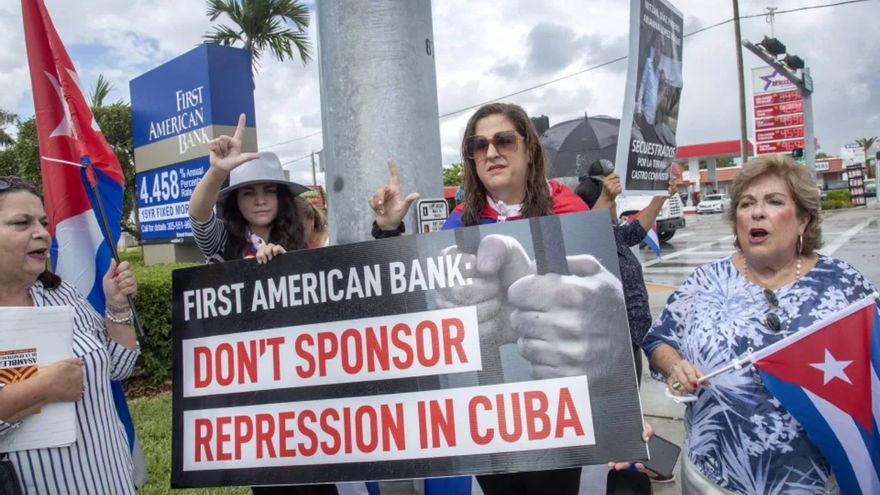 decenas de manifestantes del exilio cubano emplazaron a la entidad financiera coreando que "debería darle pena apoyar a un régimen comunista". (EFE)