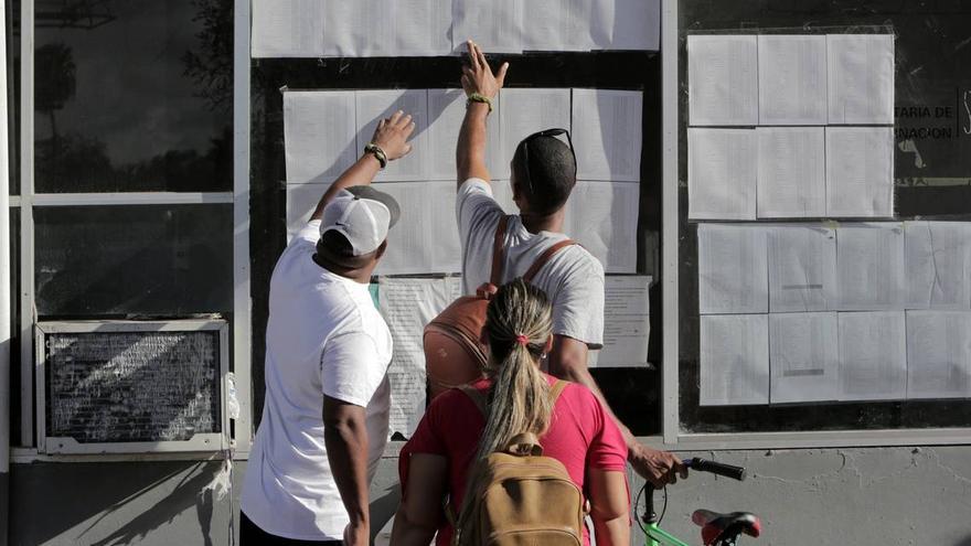 Los migrantes cubanos verifican su estado en la lista publicada en la entrada al Puente Internacional en Matamoros, México. (el Nuevo Herald)