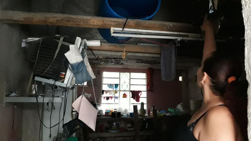 Yuderkis Pupo García intenta contener el techo de su edificio desde hace más de un mes, cuando el inmueble empeoró tras el paso del tornado. (14ymedio)